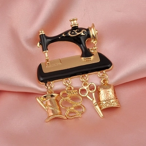 Detailed close-up of a vintage sewing machine brooch with gold charms on pink silk