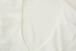 Detailed close-up of white ruffled edges and breathable mesh fabric texture on sleeve