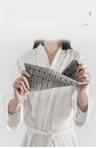 Close-up of flexible grey TPE bath mat showing 360-degree twist and drainage holes