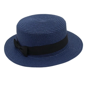 Detail of navy straw boater hat featuring fine woven texture and a black satin side bow ribbon