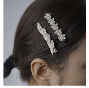 Close-up of sparkling crystal leaf and flower hair clips worn on a woman's side profile