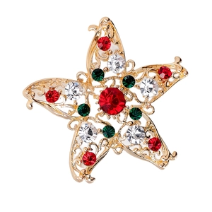 Detailed view of a gold star brooch with red and green crystals for Christmas outfits