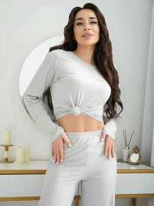 Detail of light gray two-piece pajama set with a stylish knot design on the long sleeve top