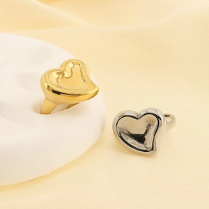 Detail of 18K gold and silver heart-shaped open rings on minimalist display