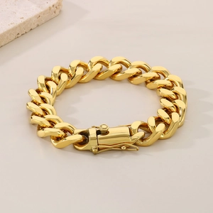 Detail of 18K gold plated 13mm Cuban link bracelet with lobster clasp on stone prop