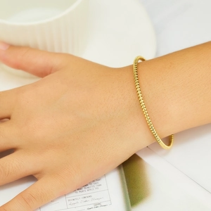 Elegant gold twisted bangle bracelet for women with fine spiral texture in stainless steel