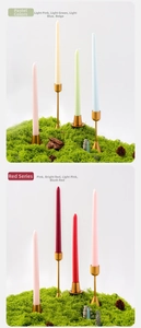 Primer plano de velas cónicas de 25 cm en soportes dorados con musgo decorativo
