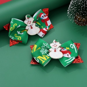 Close-up of green and red Christmas hair clips with glittery snowman accents