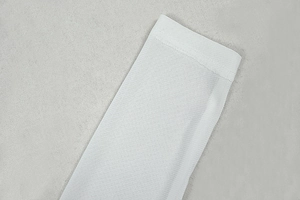 Detail of white long sleeve dress showing fine mesh knit texture and seam quality