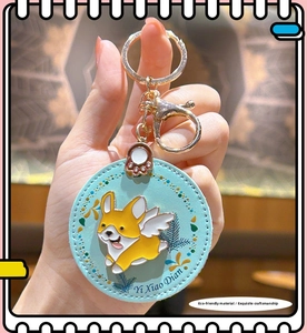 Close-up of blue leather corgi keychain with gold lobster clasp and fine stitching