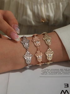 Trois bracelets Main de Fatima en or, argent et or rose sertis de strass brillants