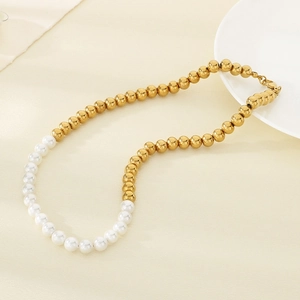 Vue détaillée des perles dorées à l'or 18 carats et perles blanches sur le collier