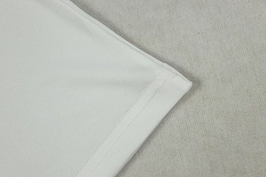 Close-up of precision double-needle hem stitching on white pleated dress fabric
