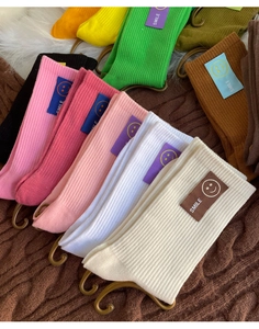 Vue détaillée de chaussettes en coton côtelé coloré avec étiquettes smile sur tricot