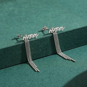 Élégantes boucles d'oreilles HAPPY en argent S925 avec pompons longs sur fond vert