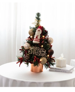 Mini tabletop Christmas tree with warm LED lights, gold ornaments and a bronze pot base