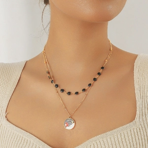 Detail einer zweilagigen Goldkette mit Himmelsmotiven aus Sonne und Mond Emaille-Anhänger
