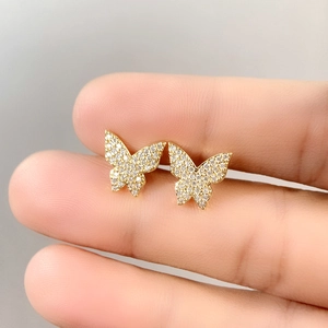 Macro shot of gold butterfly stud earrings featuring micro-pave cubic zirconia crystals