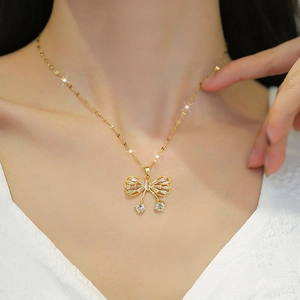 Detail of a gold butterfly necklace with zircon micro-paving on a model's collarbone