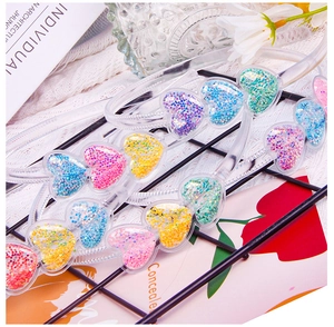 Close-up of heart-shaped sequins inside a transparent kids headband in candy colors