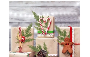 Close-up of DIY Christmas gift wrapping with pine branches, cinnamon sticks, and ribbons