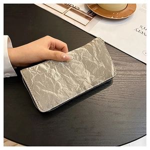 Detailed close-up of a silver long zipper wallet with unique pleated metallic texture