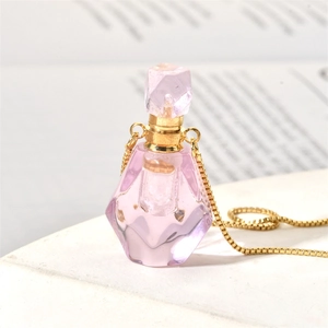 Macro shot of faceted purple crystal perfume bottle pendant with golden chain