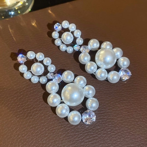 Détail de boucles d'oreilles vintage avec perles blanches et zircons brillants et éclatants