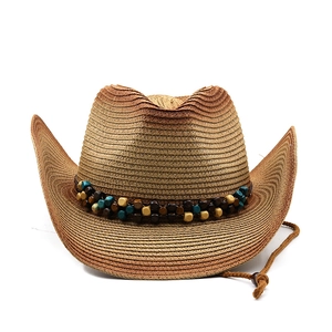 Vue détaillée du chapeau de paille de cowboy avec bande perlée colorée et mentonnière