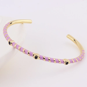 Close-up of lavender enamel gold-plated open bangle with geometric patterns and dots