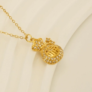 Dettaglio macro della collana con ciondolo a sacchetto portafortuna placcata oro 18k
