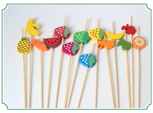 Detailed view of colorful bamboo cocktail picks with various fruit shapes on white surface