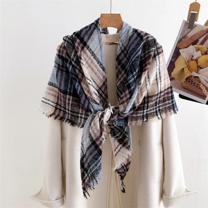 Detail of plaid cashmere-like scarf with blue and purple tones and fringed edges