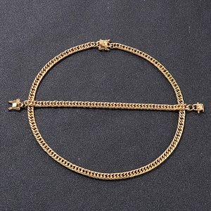 Close-up of golden Cuban link necklace and bracelet set with unique clasp on black background