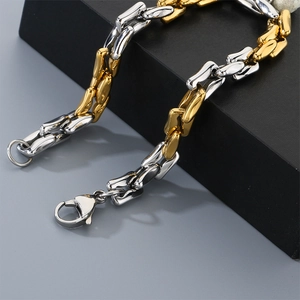 Vista de macro de una pulsera de cadena bicolor oro y plata con cierre de mosquetón