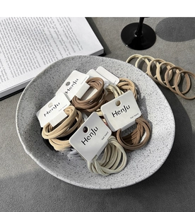 Detailed view of elastic hair bands set in earthy tones on a branded display card