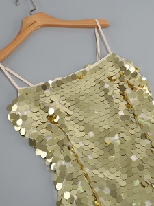Close-up of golden scale sequins and champagne thin straps on backless party dress