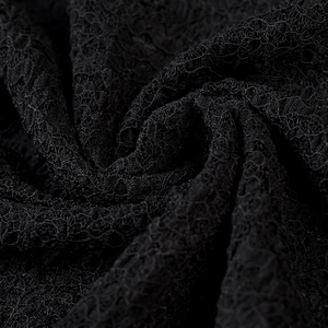 Vue macro de la texture dentelle noire complexe et détails des motifs évidés sur une jupe