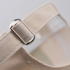 Detail shot of the metal buckle adjustment strap on a beige cotton Arizona baseball cap