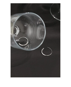 Macro shot of minimalist S925 sterling silver O-shaped hoop earrings on dark fabric