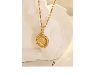 Macro detail of gold coin pendant featuring Queen Elizabeth II relief on an angel statue