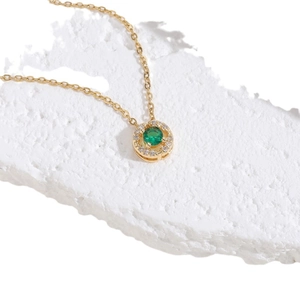 Gold emerald pendant necklace with halo of zircon crystals on a minimalist chain
