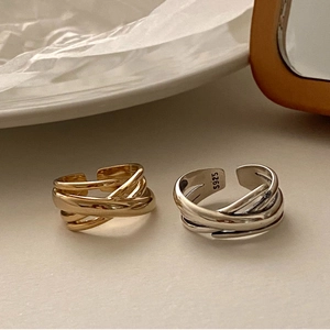 Detailed close-up of S925 sterling silver woven cross rings in gold and silver finish