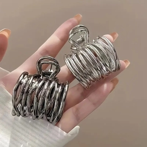 Detailed view of silver and gunmetal hollow spiral metal hair claws with strong springs