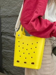 Detail of yellow EVA beach bag featuring breathable holes and white woven shoulder strap