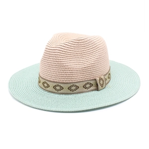 Detail of two-tone woven straw sun hat with ethnic geometric pattern ribbon band