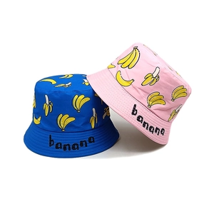 Blue and pink kids bucket hats with yellow banana prints and embroidered banana lettering
