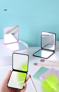 Close-up of portable square folding double-sided makeup mirrors in various pastel colors