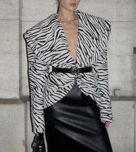 Detail of zebra print blazer and black leather skirt with metallic buckle belt