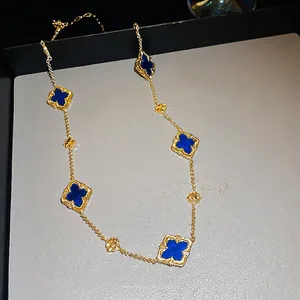 Gold plated long necklace with six blue clover motifs on a luxury display box